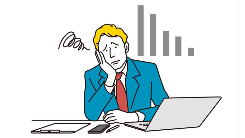 肘をつき落ち込むスーツ姿の男性