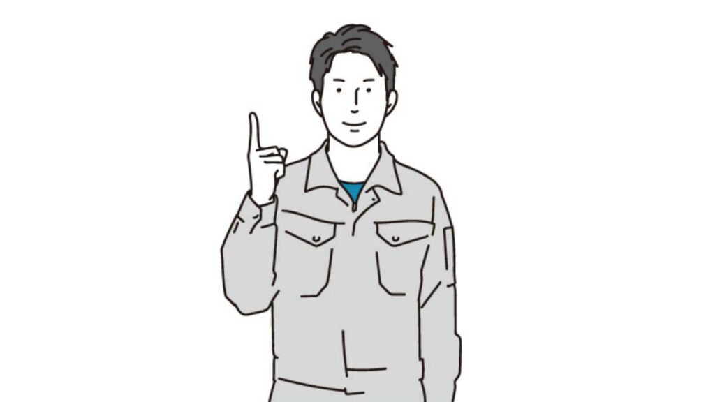 人差し指をあげて微笑む作業着の男性