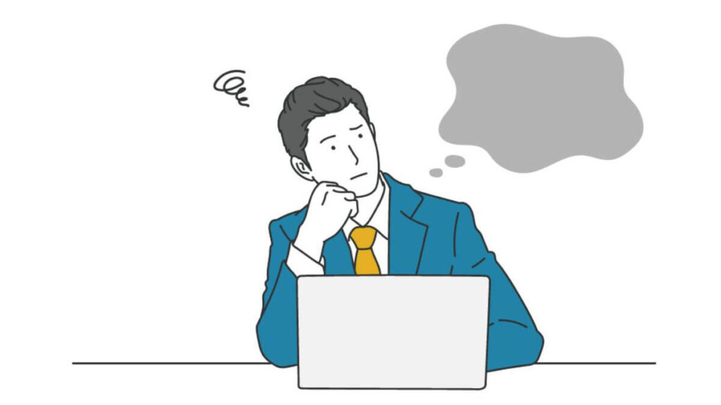 パソコン前で考えるスーツ姿の男性