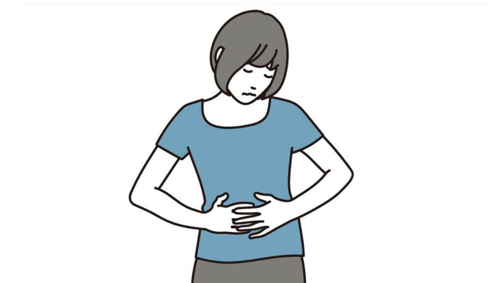 お腹を抑え体調が悪そうな女性
