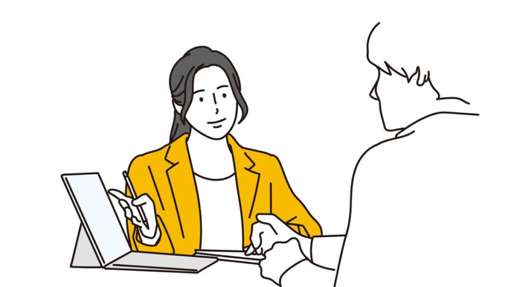 パソコンを使って説明するスーツ姿の女性