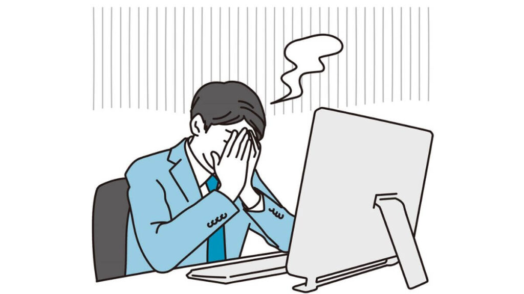 両手で顔を防ぎ後悔するスーツ姿の男性