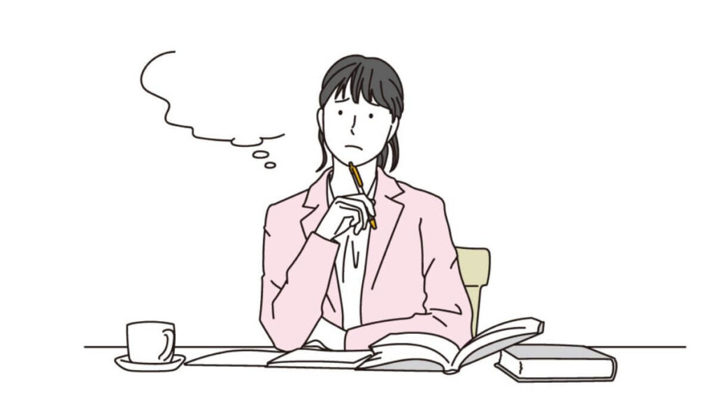 ペンを顎につけ考え事をする若い女性