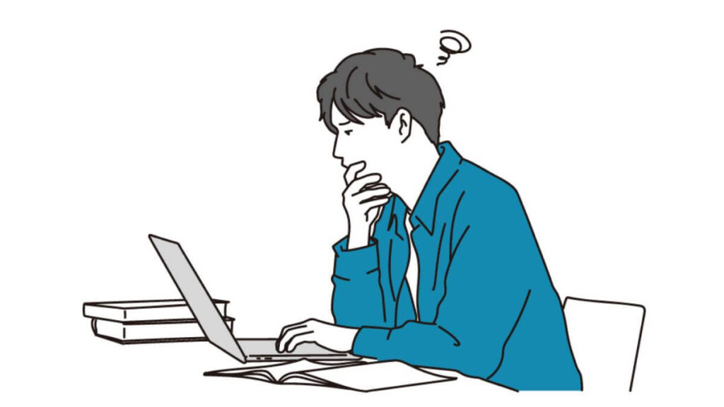 パソコンの前で深刻に悩む若い男性