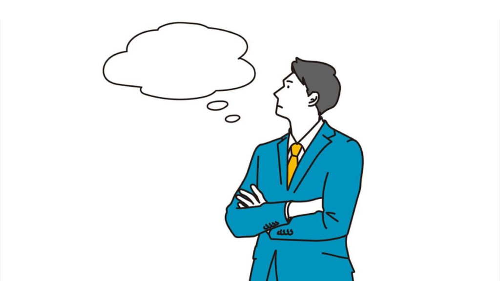 腕を組み考えるスーツ姿の男性