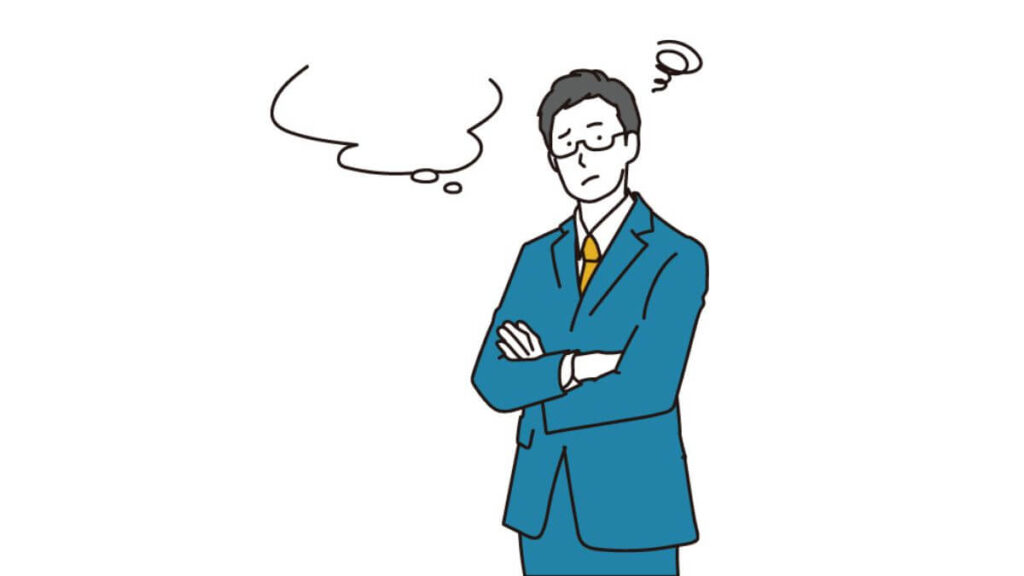 腕を組み困った表情をするスーツの男性