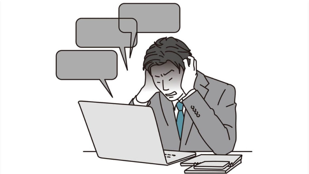 パソコン作業中にミスをして後悔するスーツの男性