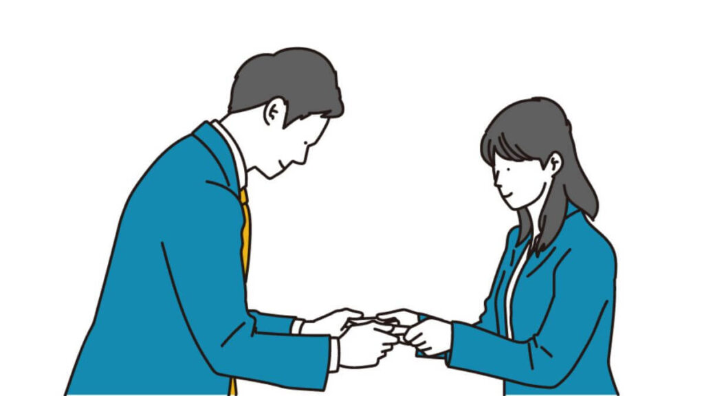 丁寧に名刺交換をするスーツ姿の男女