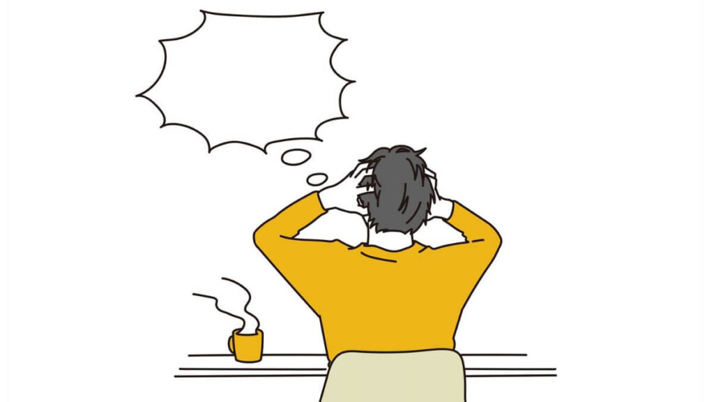 カフェで頭を抑えて混乱する男性
