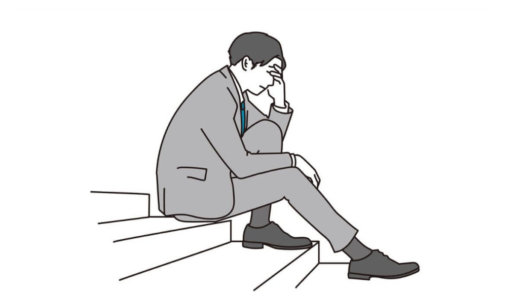 階段で落ち込むスーツ姿の男性