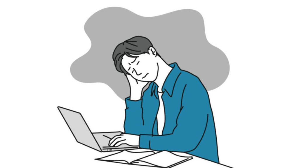 パソコンの前で暗い表情をして落ち込む男性