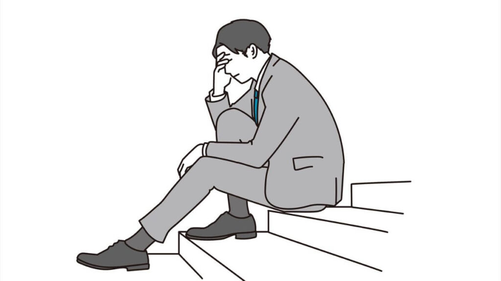 階段で落ち込む男性サラリーマン
