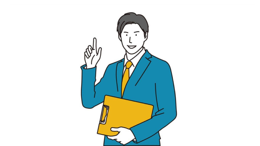 人差し指をあげて微笑むスーツ姿の男性