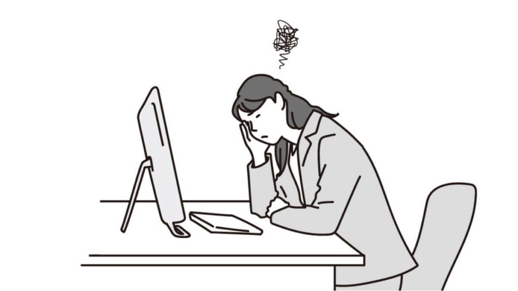 机に手をつき悩むスーツ姿の女性