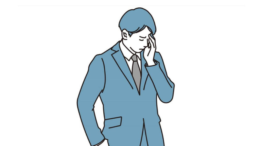 手で顔を触り落ち込むスーツ姿の男性