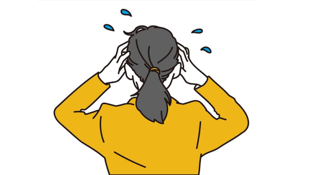 頭を抱え混乱するスーツ姿の女性