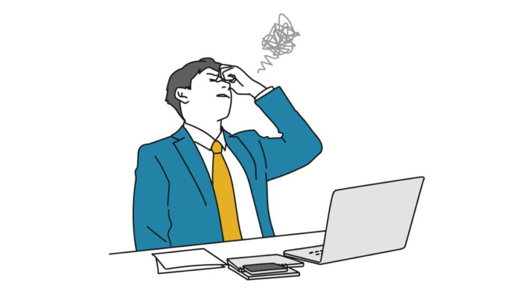 目頭を押さえて落ち込むスーツ姿の男性