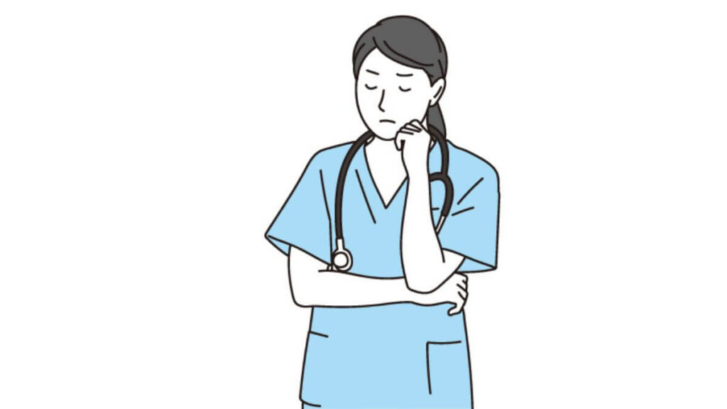 頬に手をつき考え事をする看護師の女性