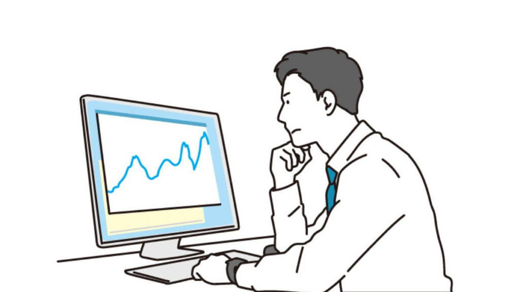 パソコンの前で難しい表情をするスーツ姿の男性