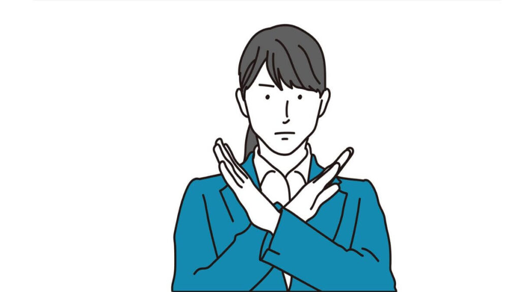 腕を使ってバツ印を出すスーツ姿の女性