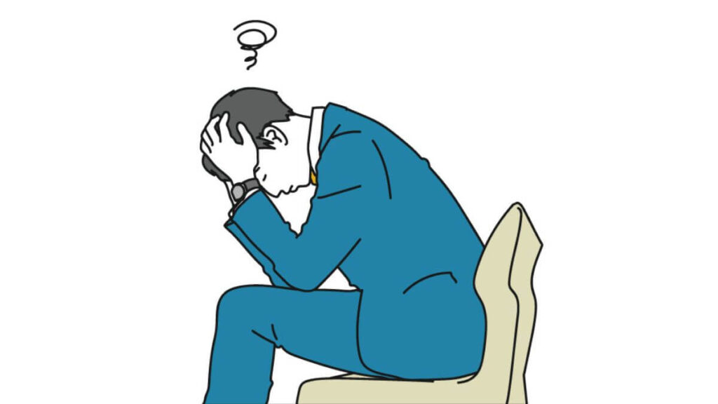 椅子に座り落ち込むスーツ姿の男性