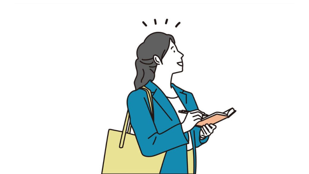 メモを書きながら仕事をするスーツ姿の女性