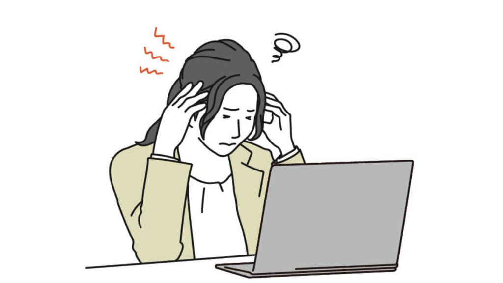 パソコン作業中に頭を抱えるスーツ姿の女性