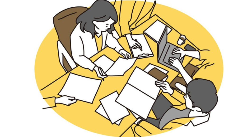 社内で忙しく働くスーツ姿の男女