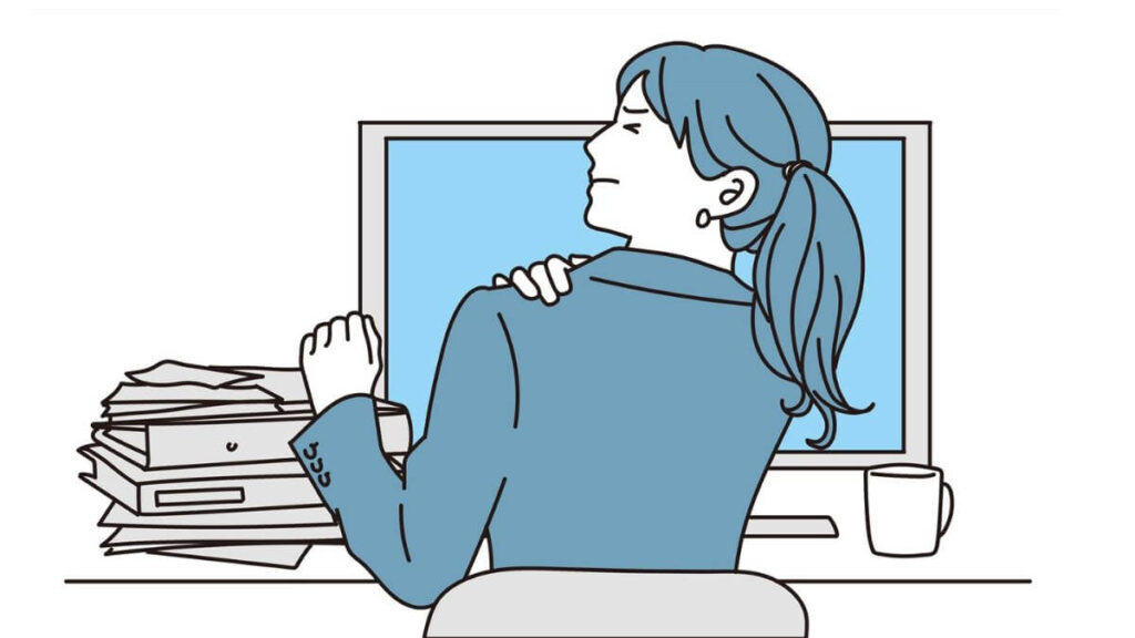 肩こりから苦しそうな表情をするスーツ姿の女性