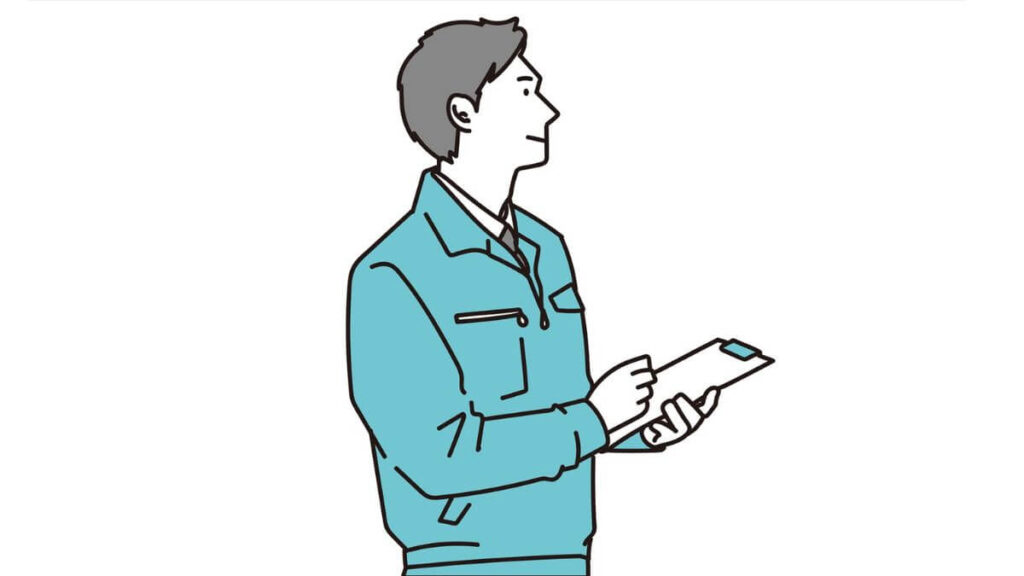 バインダーを持ち笑顔の作業着姿の男性