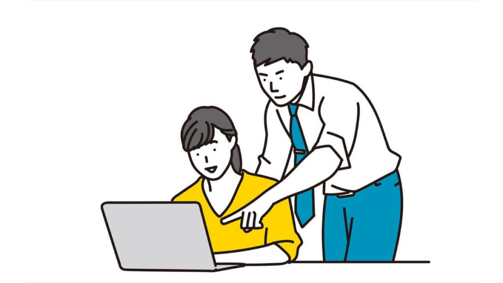 男性上司に仕事を教えてもらう若い女性