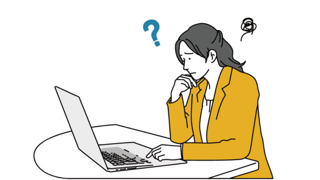 怯えた表情をしてパソコン作業をするスーツ姿の女性