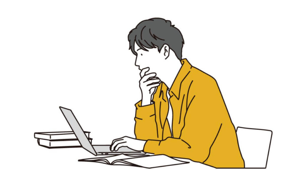 パソコンを前にして考える若い男性