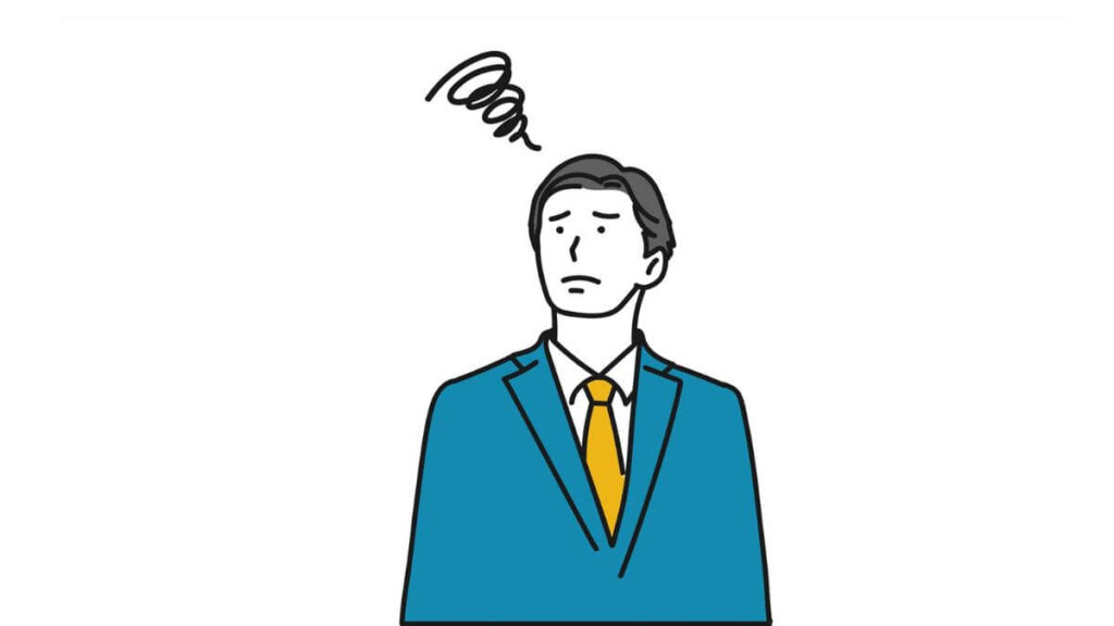 上を向き困った表情をするスーツ姿の男性