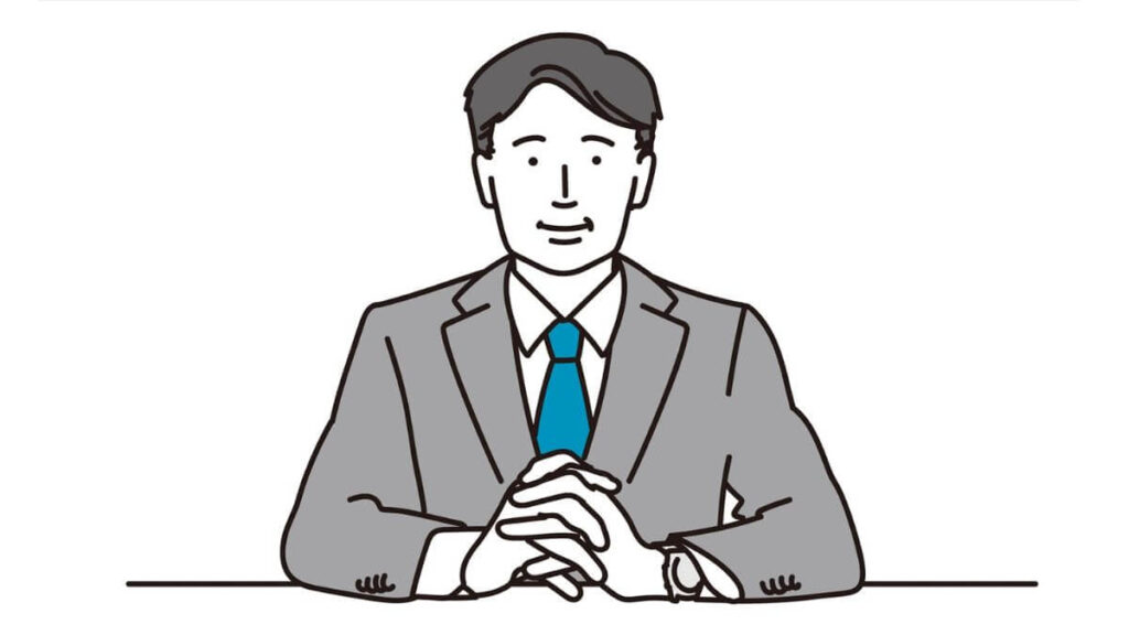 前に手を組み微笑むスーツ姿の男性