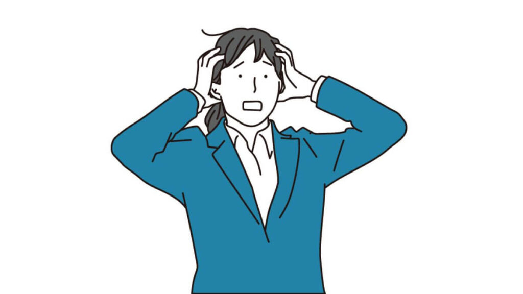 両手で頭を抱え悩むスーツ姿の女性