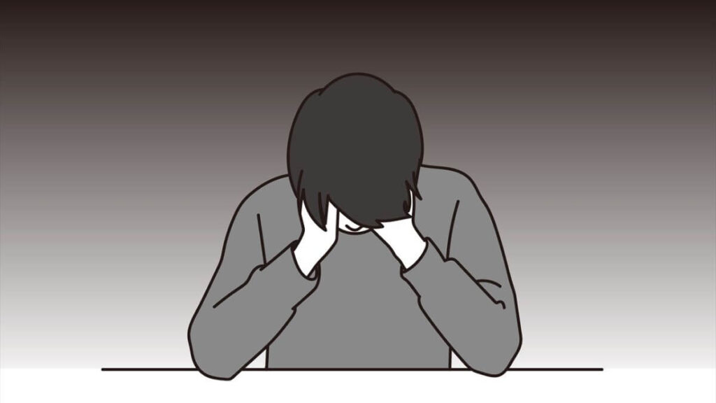 両手で顔を覆い落ち込む男性