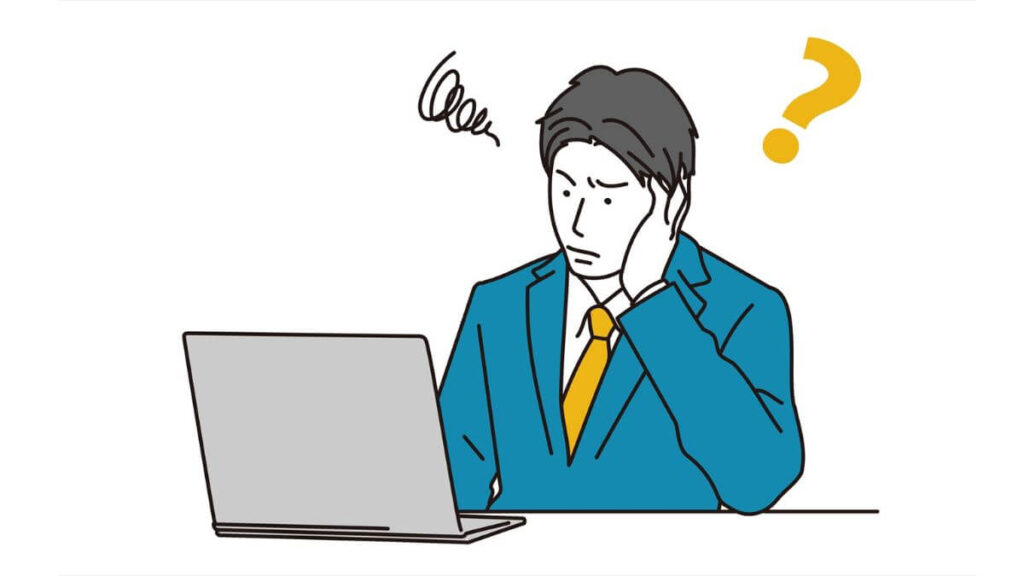 疑問を持ちながらパソコン作業をするスーツ姿の男性