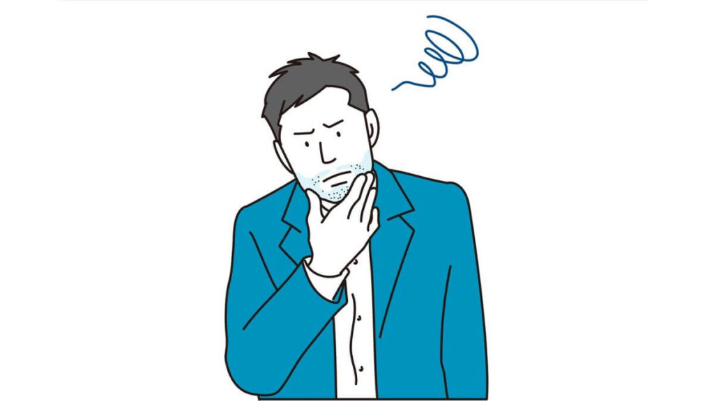 顎に手を置き困った表情をするスーツ姿の男性