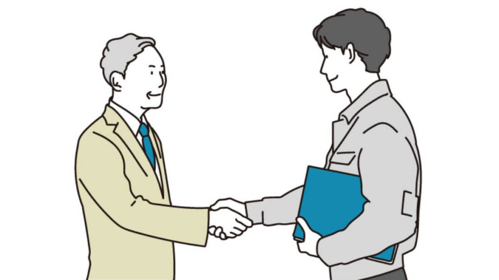 客と握手をする作業着姿の男性