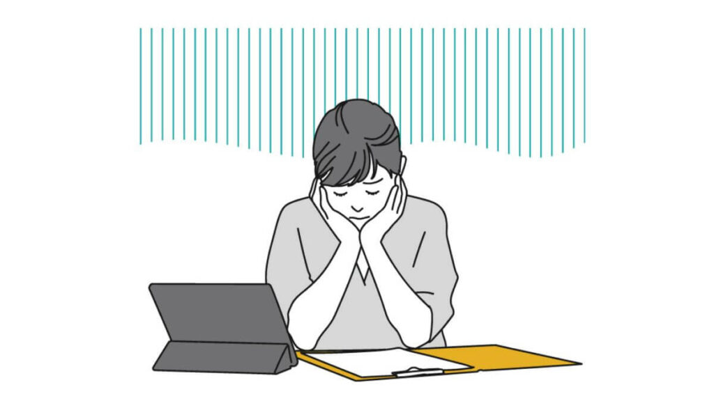 両手を顎に置き落ち込む女性