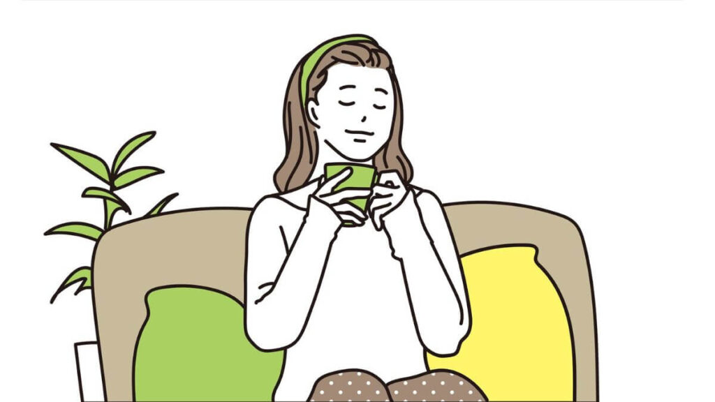 ソファーに座りコーヒーを飲む女性